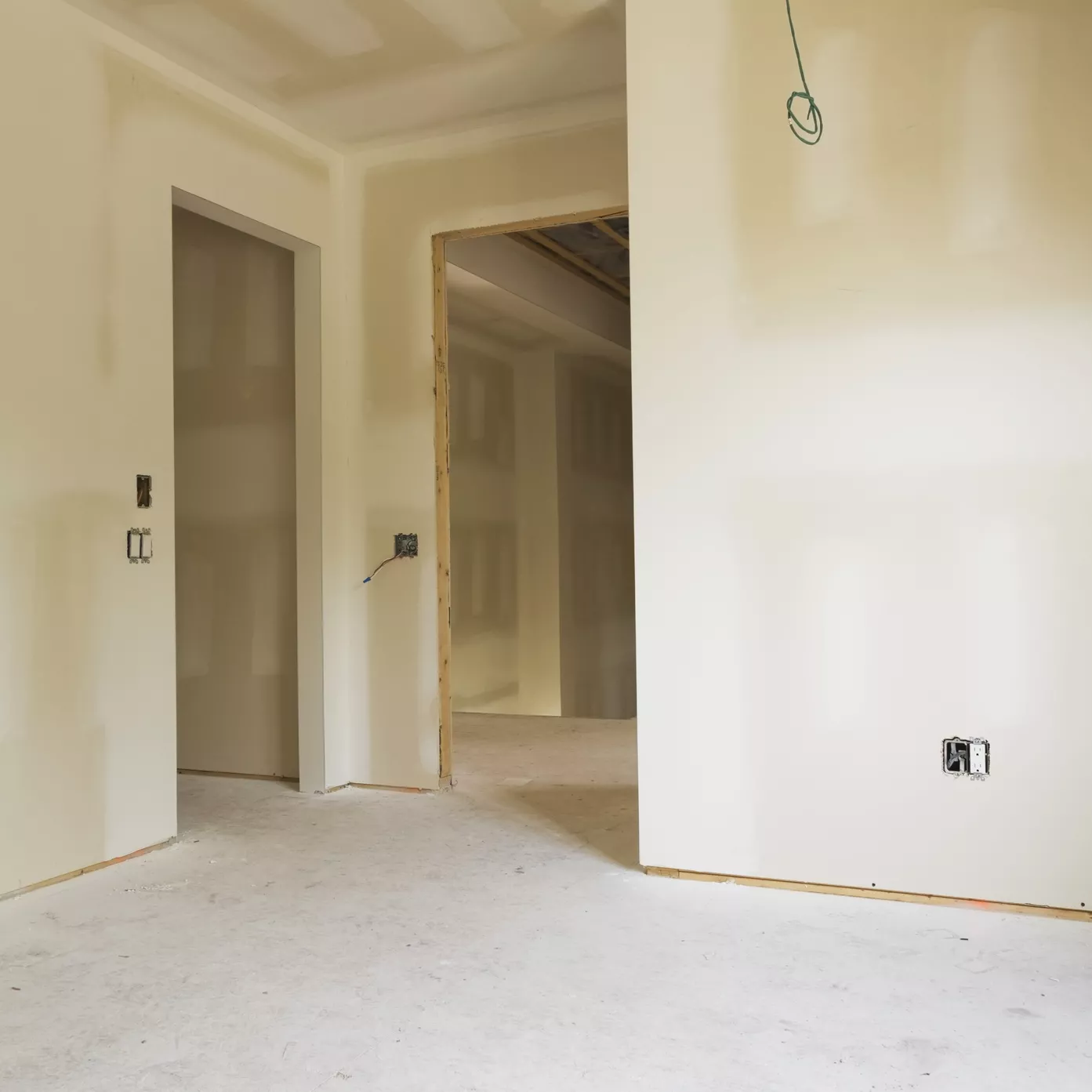 An unfinished room with hung drywall